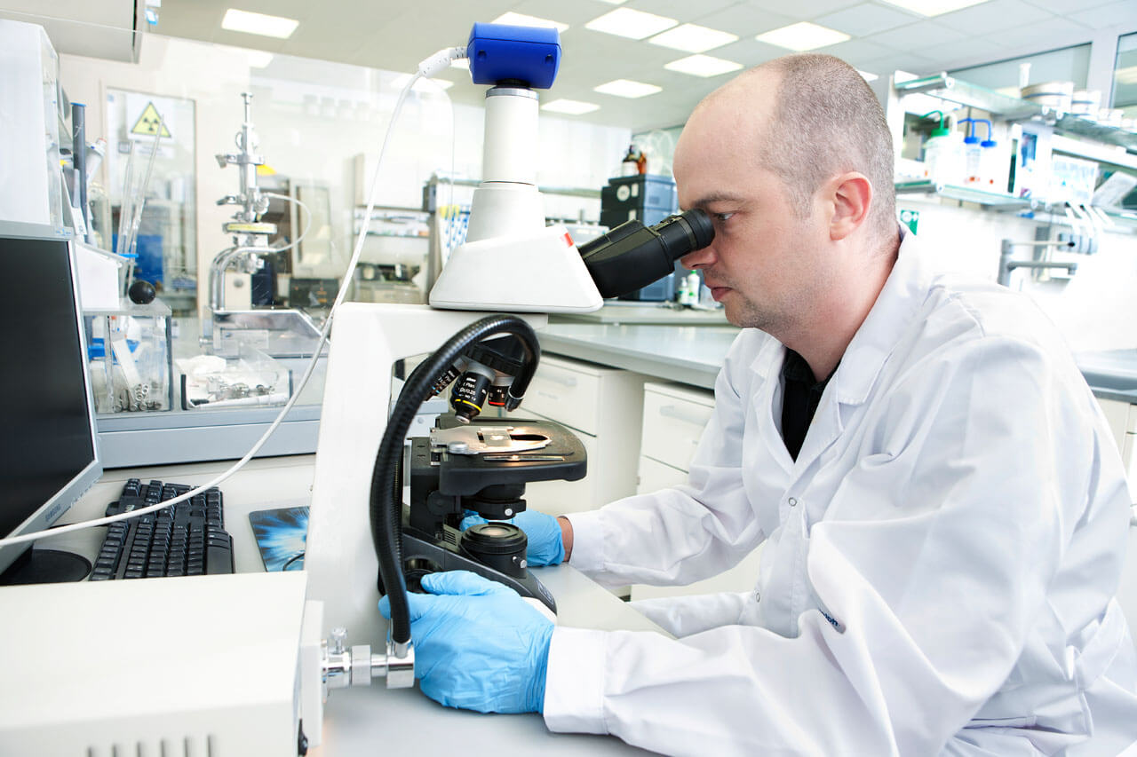 Technician looking through a microscope